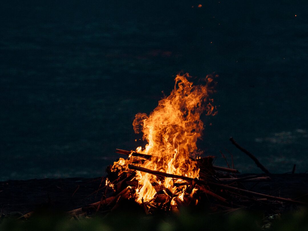 a bonfire on the beach at night