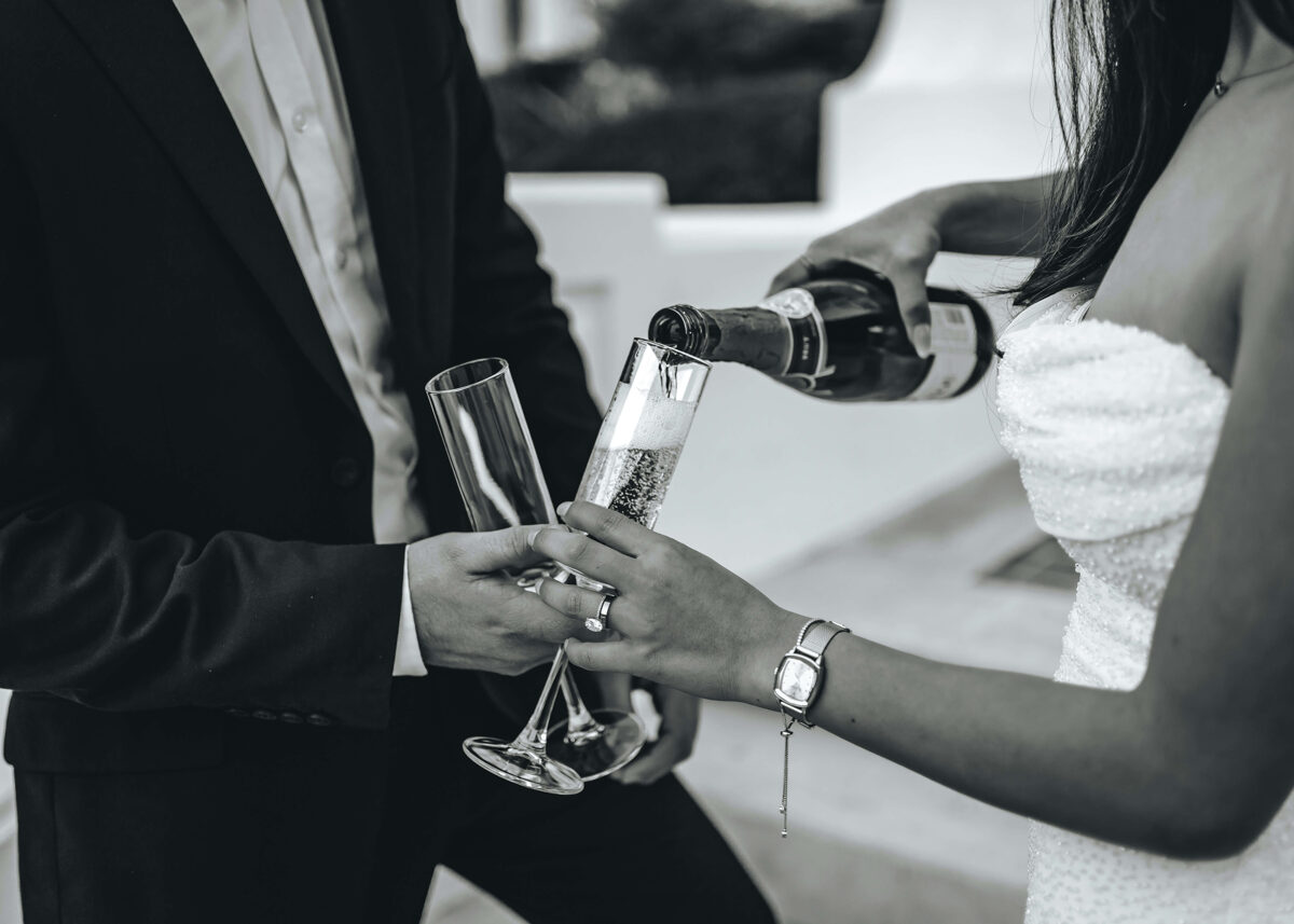 bride pouring sparkling wine into a glass