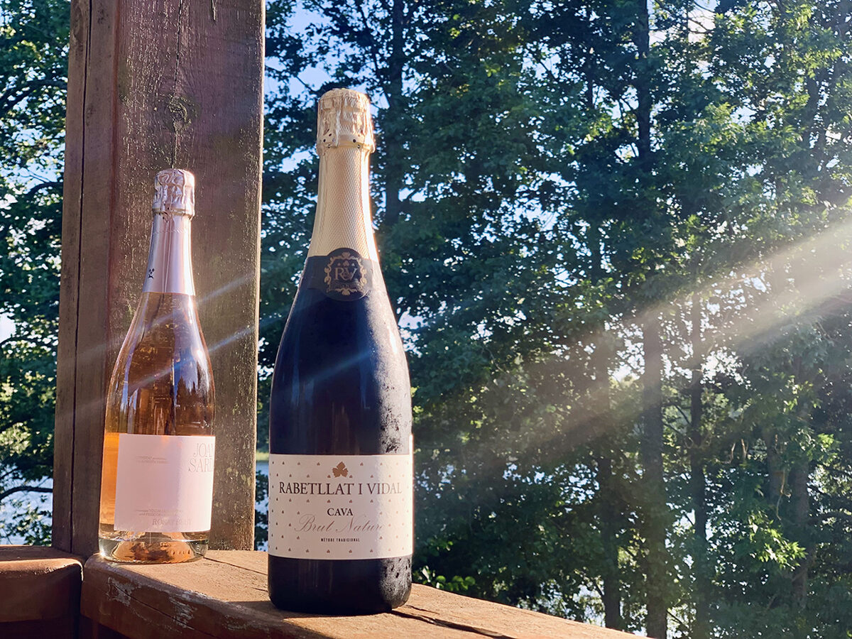 two bottles of cava wine shining under the sunset light