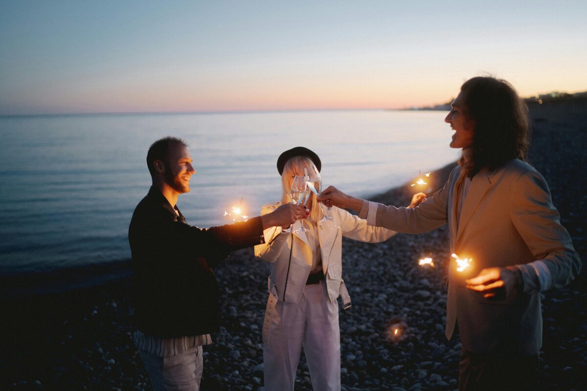 three people celebrating midsummer on the beach