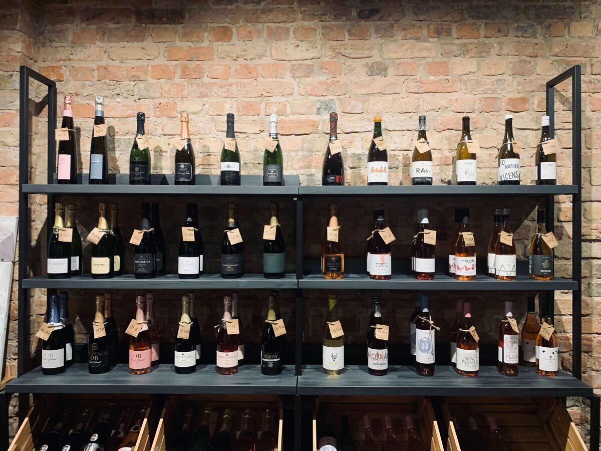 vīna pudeles stāv vertikāli veikalu plauktos