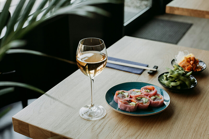 a glass of white wine and three appetizers